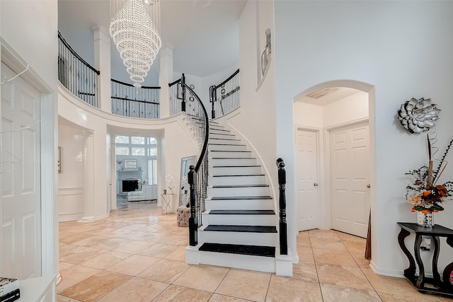 foyer featuring an inviting chandelier, light tile patterned floors, and a high ceiling