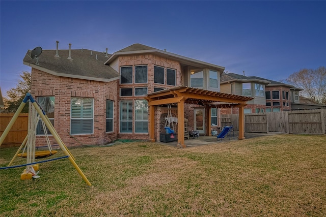 rear view of property featuring a patio, a playground, and a lawn