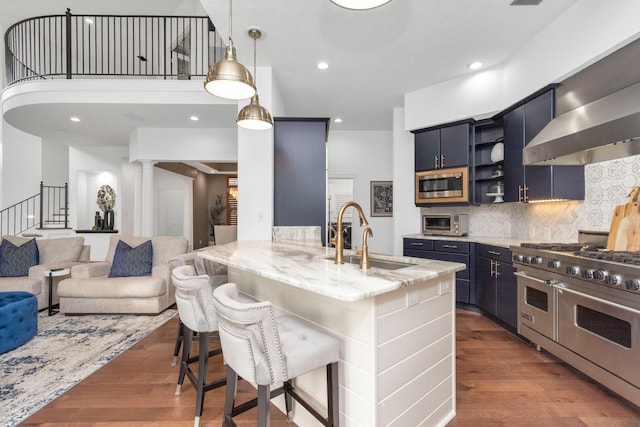 kitchen with pendant lighting, decorative backsplash, a breakfast bar area, blue cabinets, and appliances with stainless steel finishes