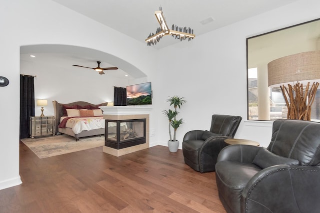 bedroom with a multi sided fireplace and hardwood / wood-style floors