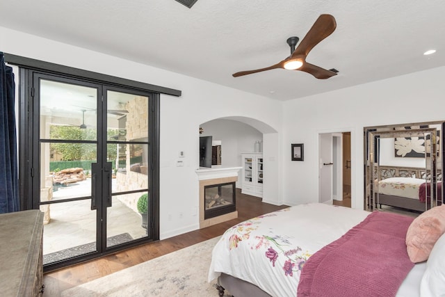 bedroom featuring dark wood-type flooring, french doors, ceiling fan, and access to exterior