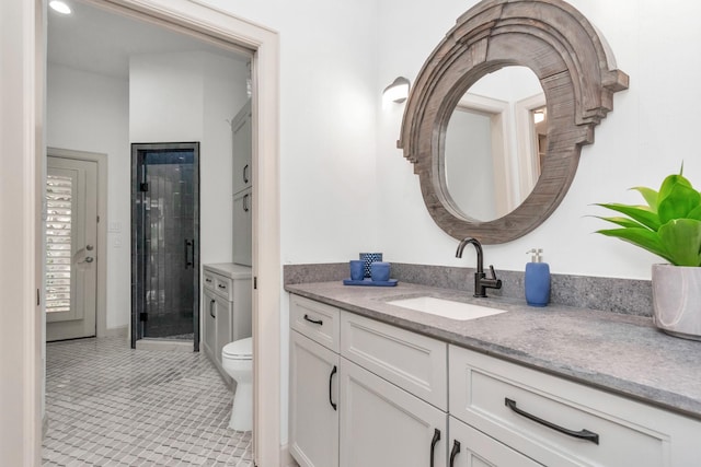 bathroom featuring toilet, an enclosed shower, tile patterned flooring, and vanity