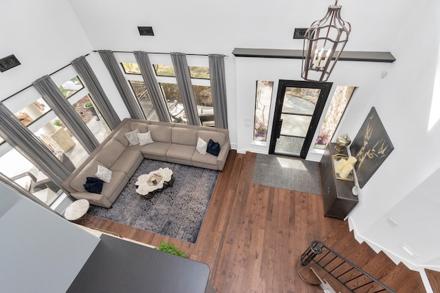 living room featuring a chandelier and dark wood-type flooring