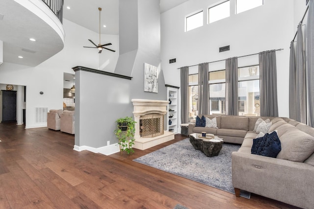 living room featuring a high ceiling, ceiling fan, and hardwood / wood-style floors