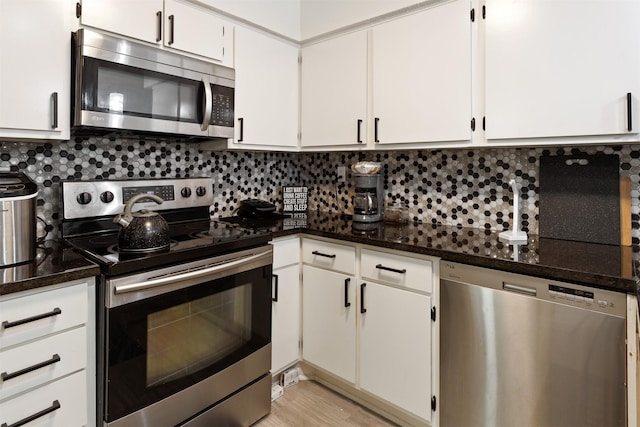 kitchen with white cabinets, backsplash, and appliances with stainless steel finishes