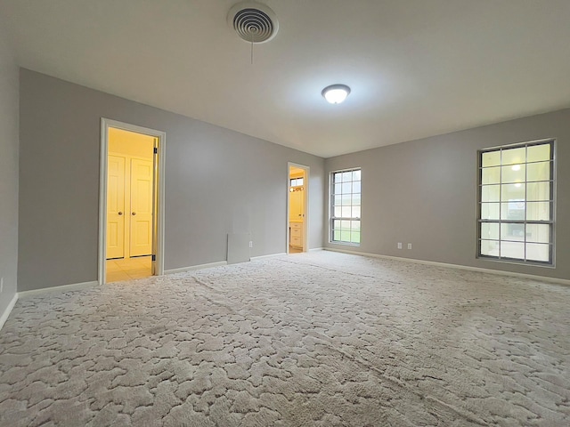 spare room featuring light carpet