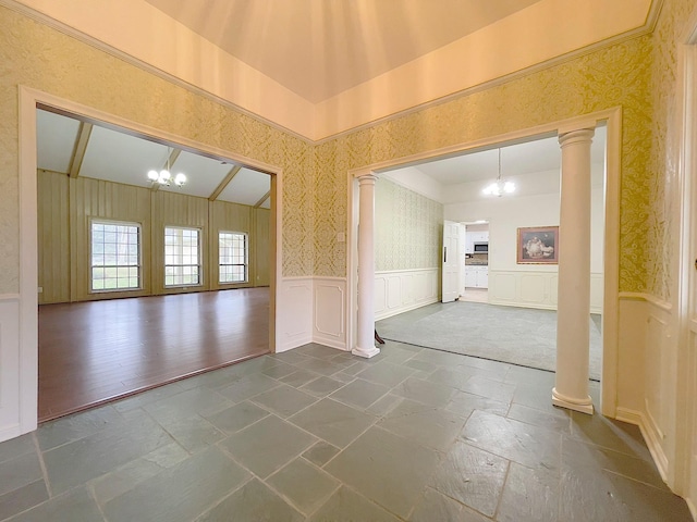 spare room with ornate columns and a notable chandelier