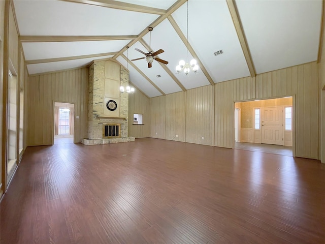 unfurnished living room with ceiling fan with notable chandelier, hardwood / wood-style floors, a brick fireplace, beamed ceiling, and high vaulted ceiling