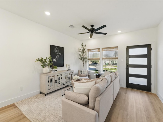 living room featuring light wood-type flooring and ceiling fan