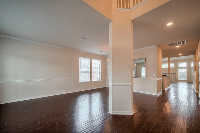 unfurnished room featuring baseboards, visible vents, plenty of natural light, ornamental molding, and dark wood-type flooring