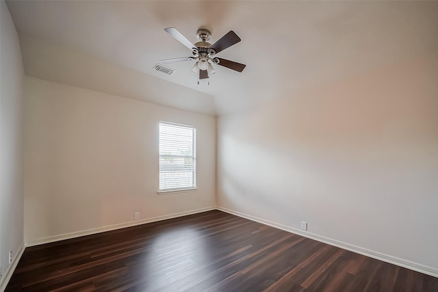 unfurnished room featuring baseboards, visible vents, dark wood finished floors, ceiling fan, and vaulted ceiling