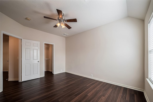 unfurnished bedroom featuring dark wood finished floors, baseboards, visible vents, and ceiling fan