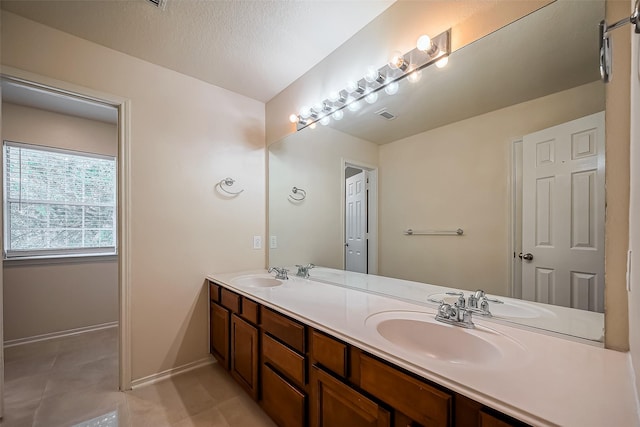 bathroom with a sink, baseboards, and double vanity