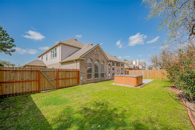 view of yard featuring a hot tub and a fenced backyard