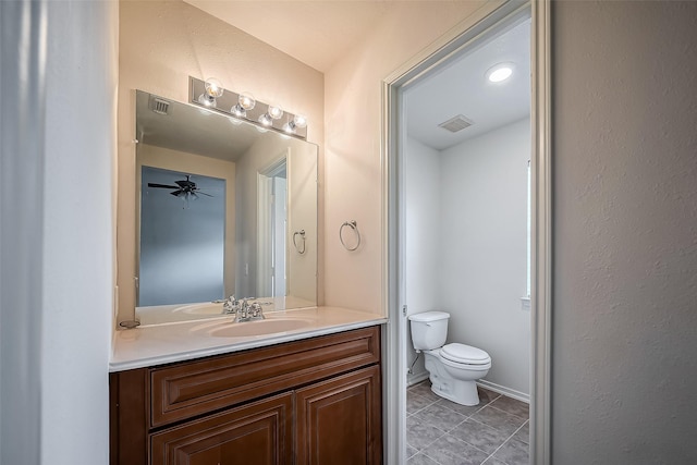 half bath featuring tile patterned flooring, visible vents, baseboards, toilet, and vanity