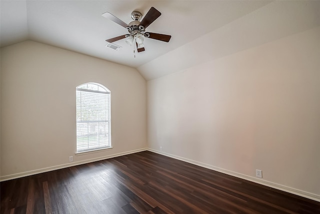 empty room with visible vents, dark wood-type flooring, a ceiling fan, baseboards, and vaulted ceiling