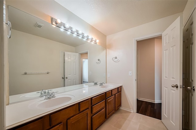 full bath featuring double vanity, visible vents, and a sink