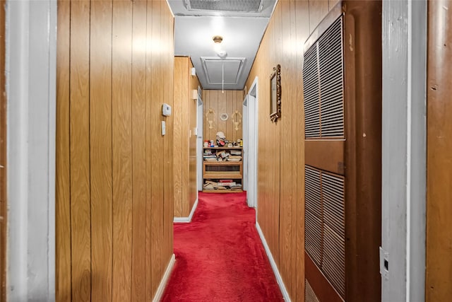 corridor featuring wood walls and carpet flooring