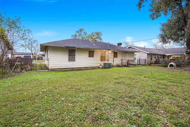 rear view of property featuring central AC unit and a yard