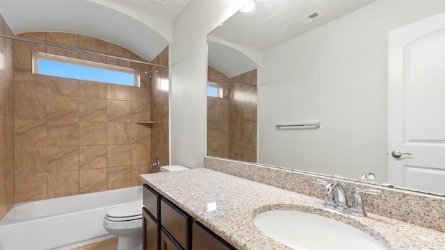 full bathroom featuring vaulted ceiling, tiled shower / bath, tile patterned flooring, toilet, and vanity