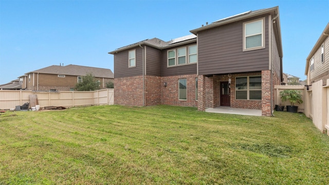 rear view of property featuring a patio and a yard