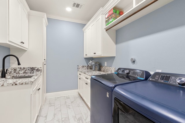 laundry area featuring cabinets, ornamental molding, washing machine and clothes dryer, and sink