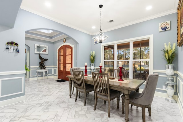 dining area with french doors, a notable chandelier, crown molding, and light parquet floors