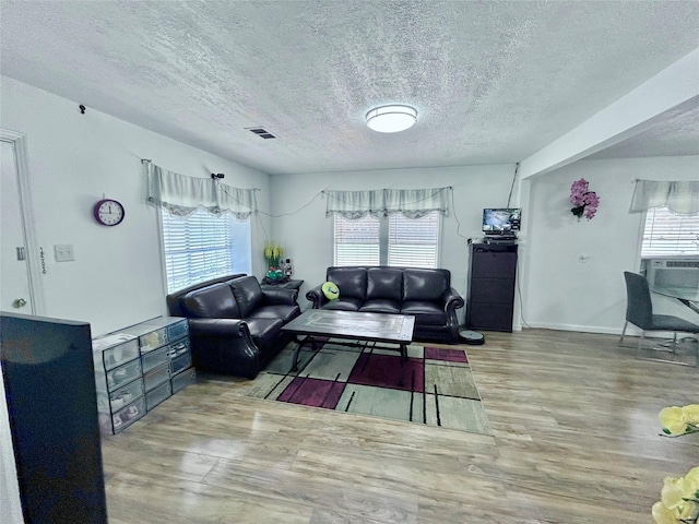 living room featuring a textured ceiling and light wood-type flooring