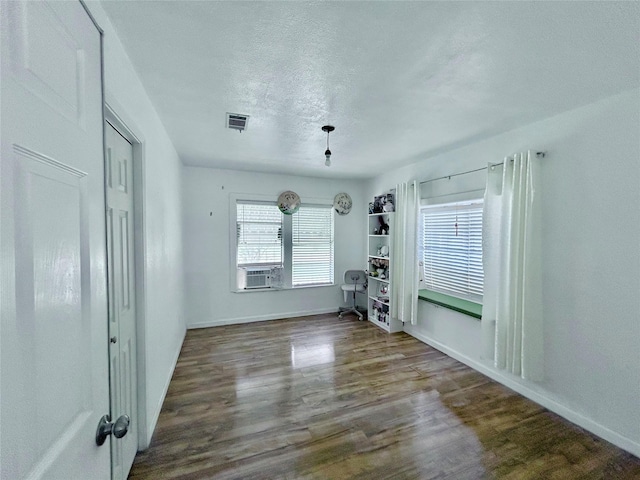 unfurnished room featuring cooling unit, a textured ceiling, and dark hardwood / wood-style floors