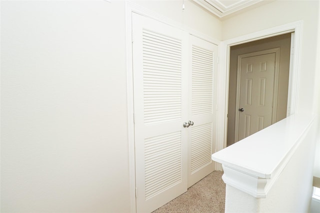 corridor featuring crown molding and light carpet