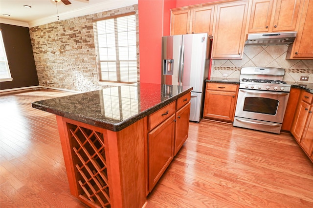 kitchen with a center island, stainless steel appliances, tasteful backsplash, crown molding, and dark stone counters