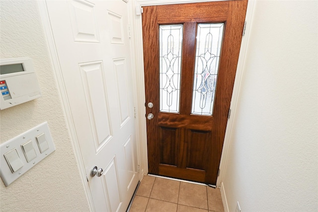 doorway to outside featuring light tile patterned flooring