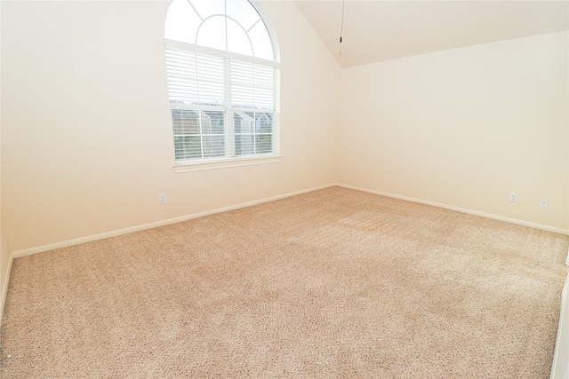 spare room with vaulted ceiling and carpet