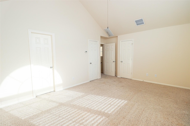 unfurnished bedroom featuring high vaulted ceiling and carpet