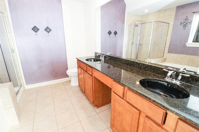 bathroom featuring vanity, a shower with door, tile patterned flooring, and toilet