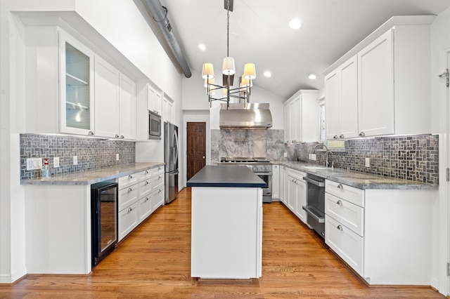 kitchen featuring a kitchen island, white cabinets, appliances with stainless steel finishes, and wine cooler