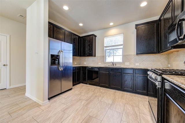 kitchen with black appliances, sink, backsplash, and light stone countertops