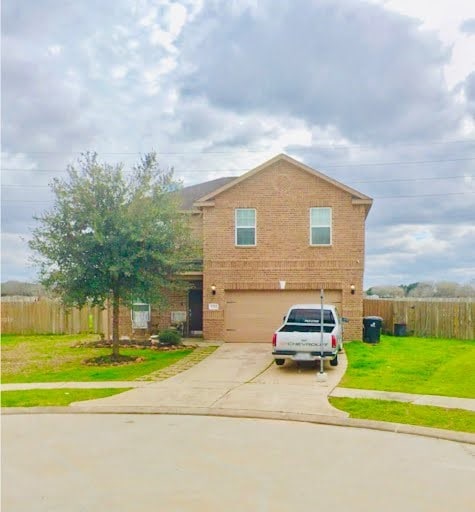 view of front of property with a garage and a front lawn