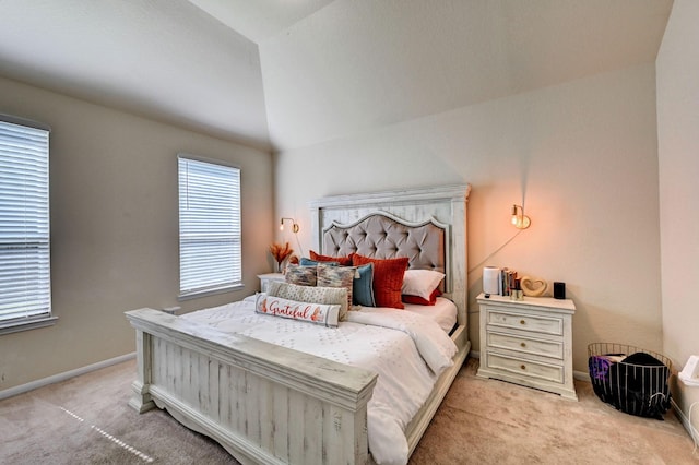 bedroom with multiple windows, lofted ceiling, and light colored carpet