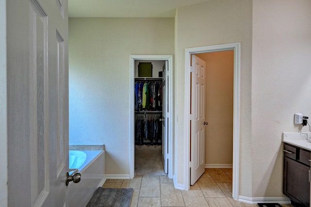 bathroom featuring a bathtub, tile patterned flooring, and vanity