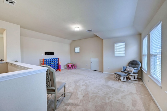 sitting room with light carpet and vaulted ceiling