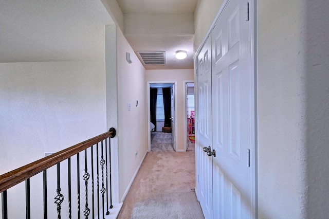 corridor featuring light colored carpet