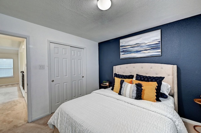 carpeted bedroom with a closet and a textured ceiling