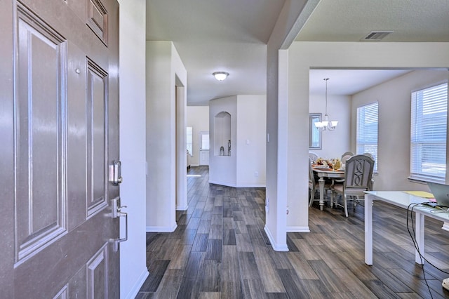 foyer entrance featuring a chandelier and dark hardwood / wood-style flooring