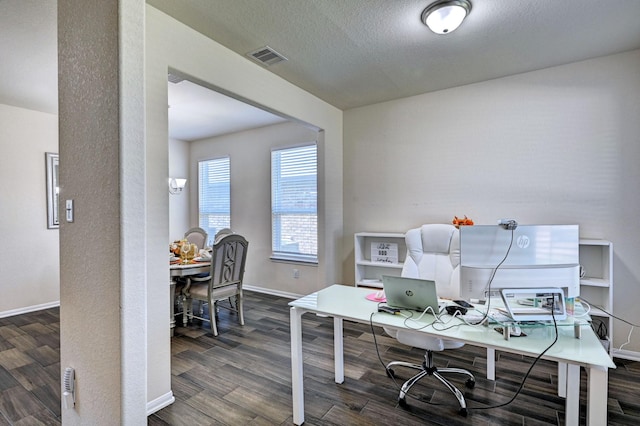 home office featuring dark wood-type flooring and a textured ceiling