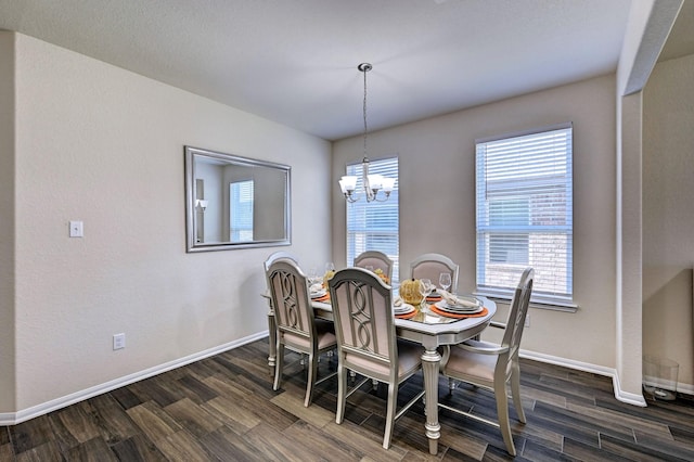 dining room with dark hardwood / wood-style flooring and a chandelier