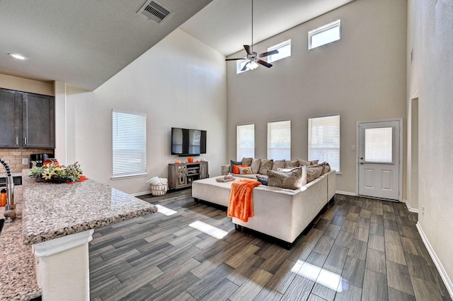 living room with ceiling fan and a high ceiling