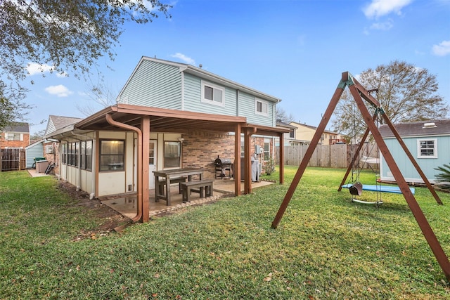 back of property with a storage shed, a sunroom, a patio, and a lawn