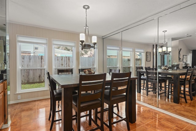 dining area featuring crown molding, a chandelier, and tile patterned flooring