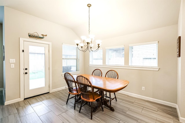 dining area featuring lofted ceiling and a chandelier